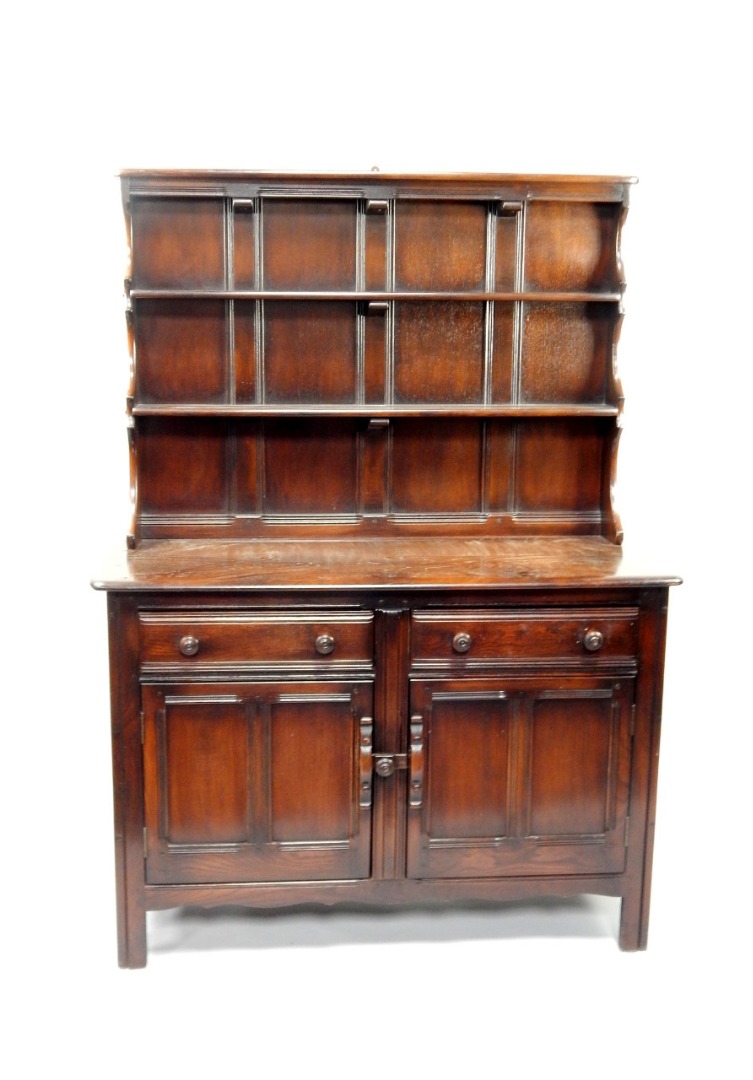 Appraisal: An Ercol dark oak dresser having shelved plate rack above