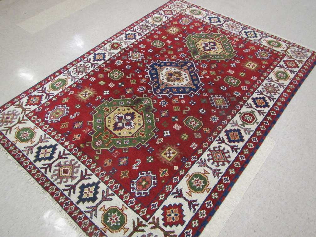 Appraisal: HAND KNOTTED ORIENTAL CARPET Indo-Caucasian three geometric medallion design on