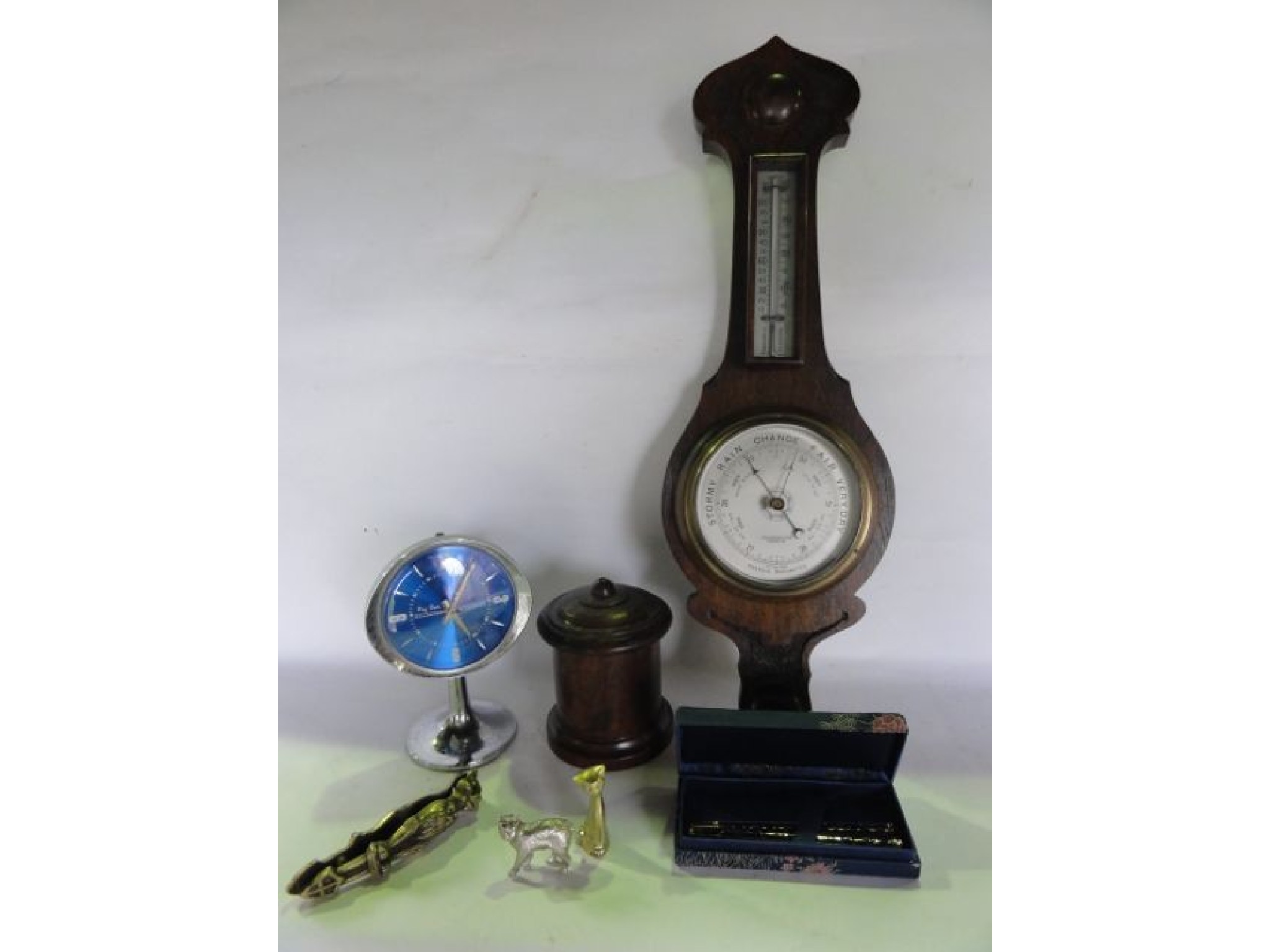 Appraisal: An oak cased wall hanging wheel barometer with silvered dials