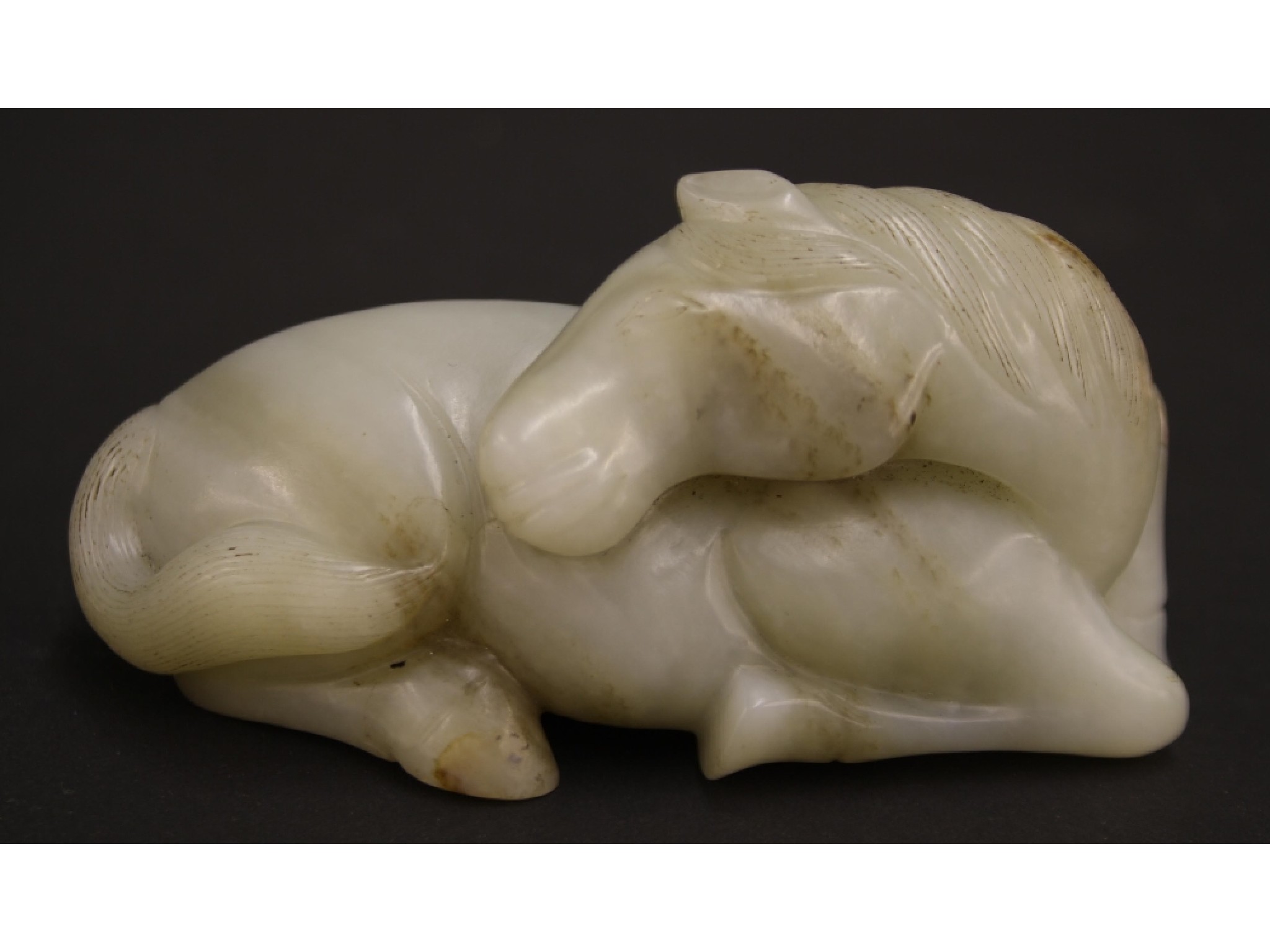 Appraisal: Qing dynasty celadon and russet jade carving of a horse