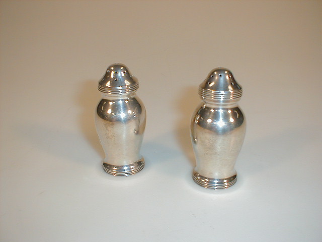 Appraisal: A pair of Edwardian silver pepper pots of baluster form