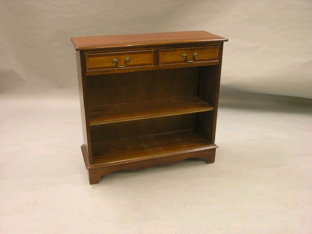 Appraisal: A reproduction mahogany open bookcase cross-banded top above a pair