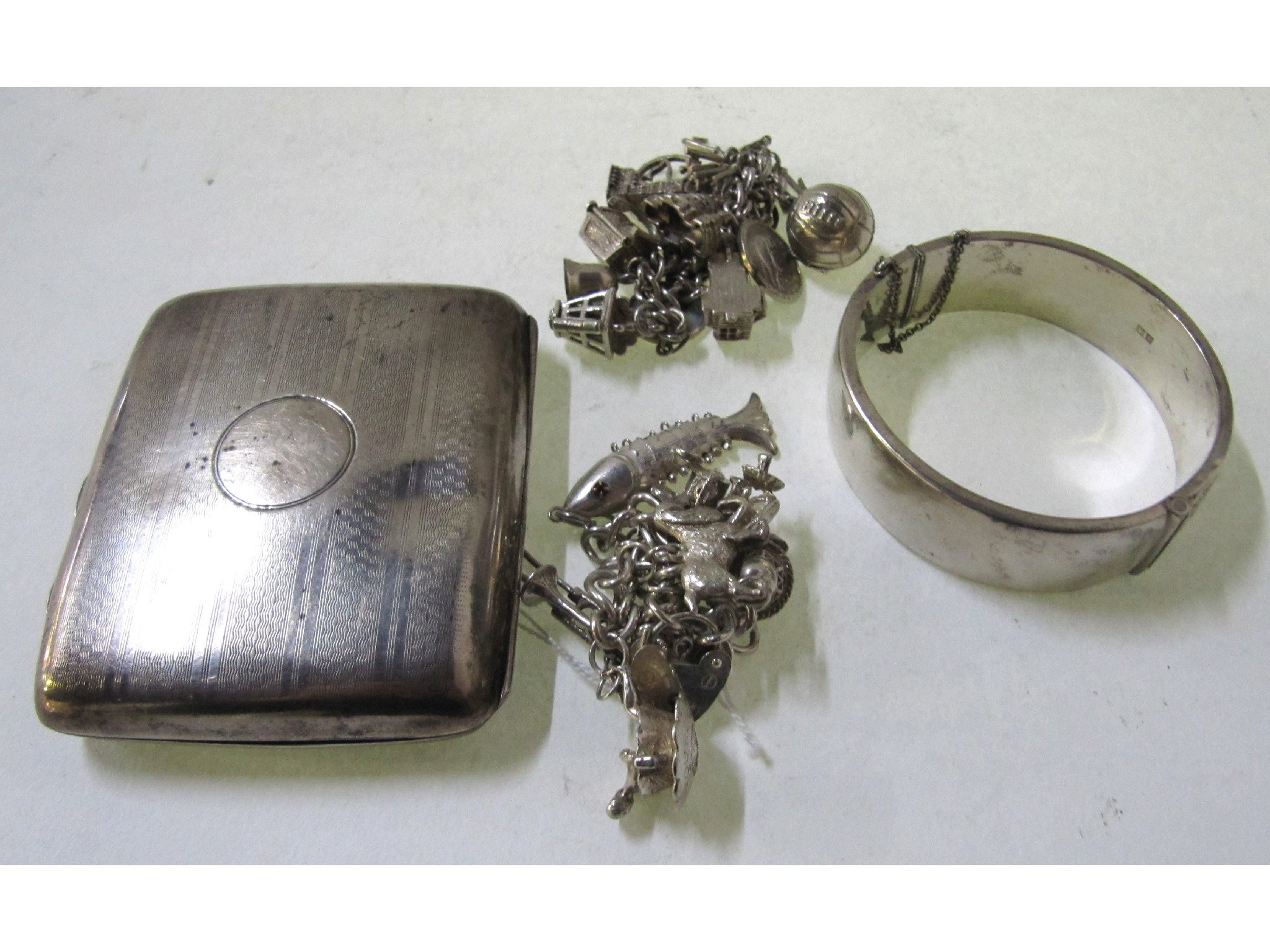 Appraisal: A lot comprising a silver cigarette case two charm bracelets