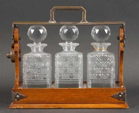 Appraisal: Victorian oak tantalus with three molded glass decanters Estimate -