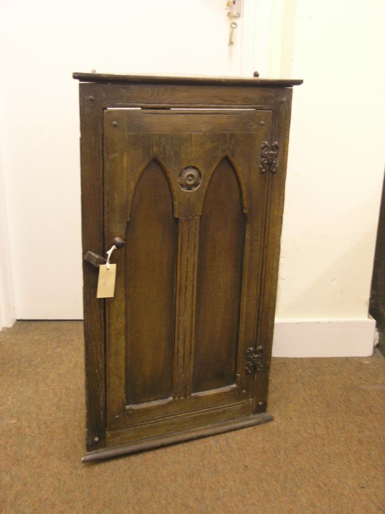 Appraisal: A small oak corner cupboard enclosed by gothic panelled door