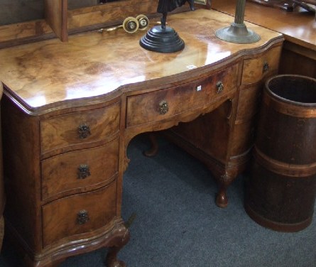 Appraisal: A walnut serpentine dressing table with triptych mirror and seven