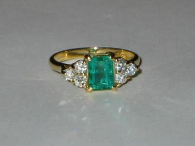 Appraisal: A DIAMOND AND EMERALD RING the trapp cut emerald flanked