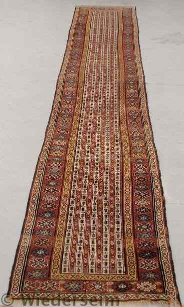 Appraisal: Long Persian oriental hall runner with a floral red border