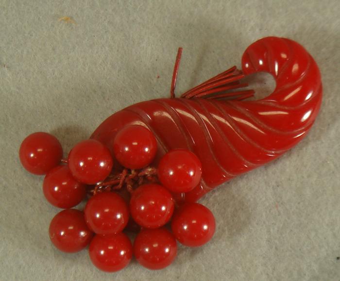 Appraisal: Red bakelite cherry cornucopia pin l Estimate -