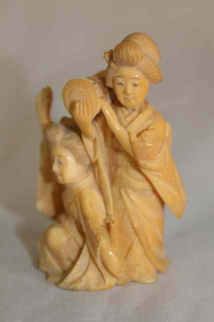 Appraisal: A JAPANESE CARVED IVORY OKIMONO in the form of two