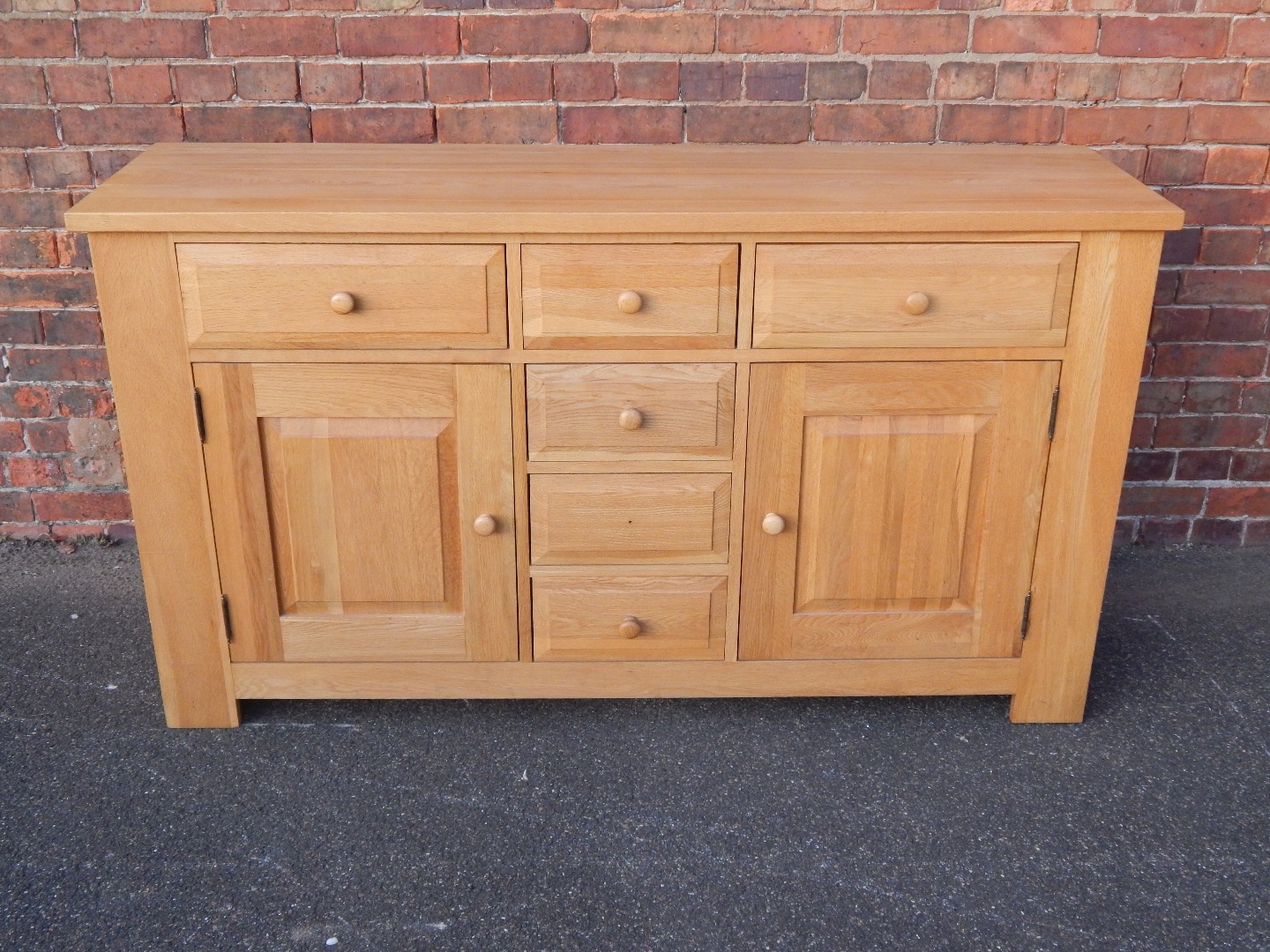 Appraisal: An oak sideboard with three drawers over two central doors