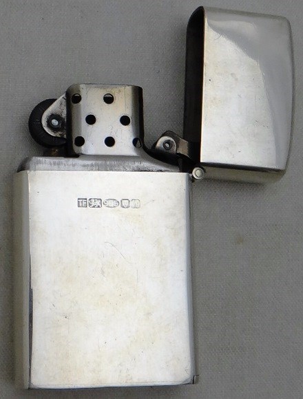 Appraisal: A silver cased petrol lighter of plain rectangular form detailed