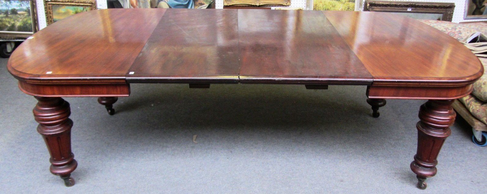 Appraisal: A Victorian mahogany extending dining table on fluted supports with