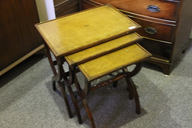 Appraisal: A REPRODUCTION NEST OF TABLES with leather tops