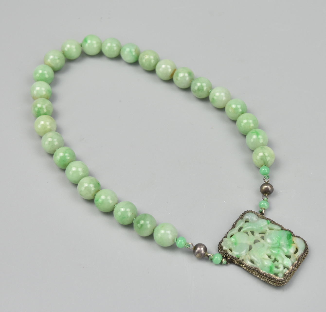 Appraisal: CHINESE BEADED JADEITE SILVER NECKLACE QING D A green jadeite