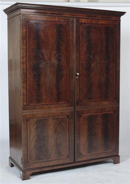 Appraisal: A th century feathered mahogany wardrobe the projected moulded dentil