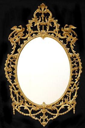 Appraisal: GEORGE III-STYLE CARVED GILTWOOD OVAL MIRROR Th pierced framework carved