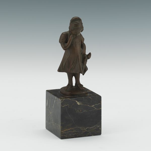 Appraisal: BRONZE FIGURINE OF A GIRL HOLDING A HARLEQUIN DOLL x