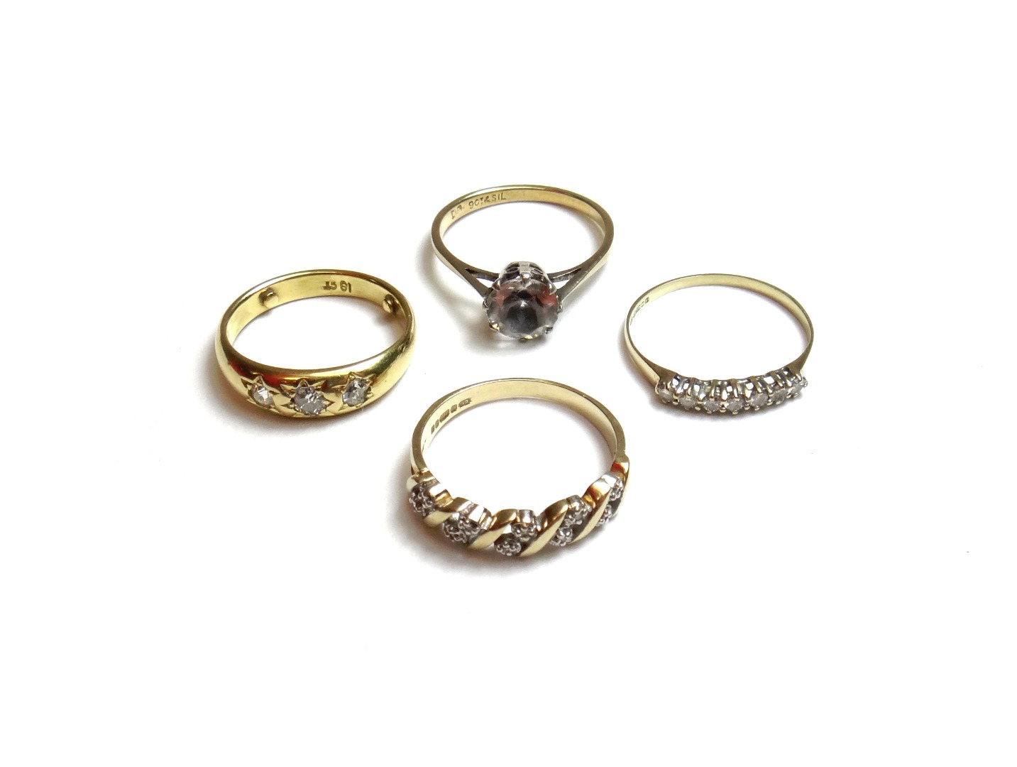 Appraisal: A gold and diamond set three stone ring gypsy set