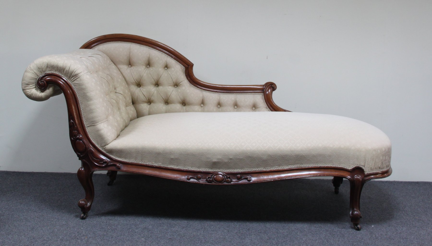 Appraisal: A Victorian carved mahogany framed chaise longue with button upholstered