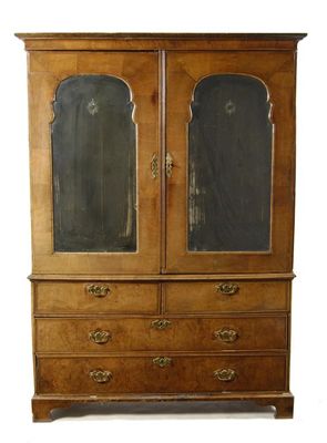 Appraisal: A walnut cabinet on chest the moulded cornice above a