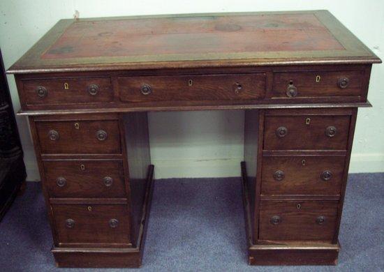 Appraisal: A mahogany kneehole desk fitted a surround of nine drawers