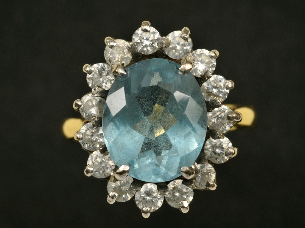 Appraisal: A Topaz and Diamond Cluster Ring the central oval-cut topaz