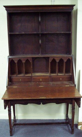 Appraisal: An oak bureau with open shelves above a carved fall