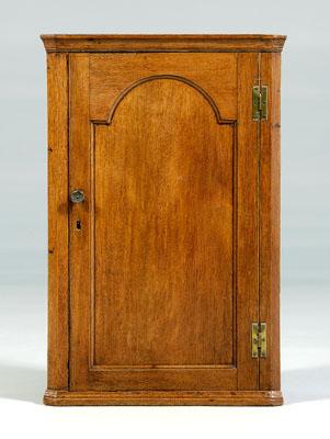 Appraisal: Georgian oak hanging corner cupboard single arched panel door opening