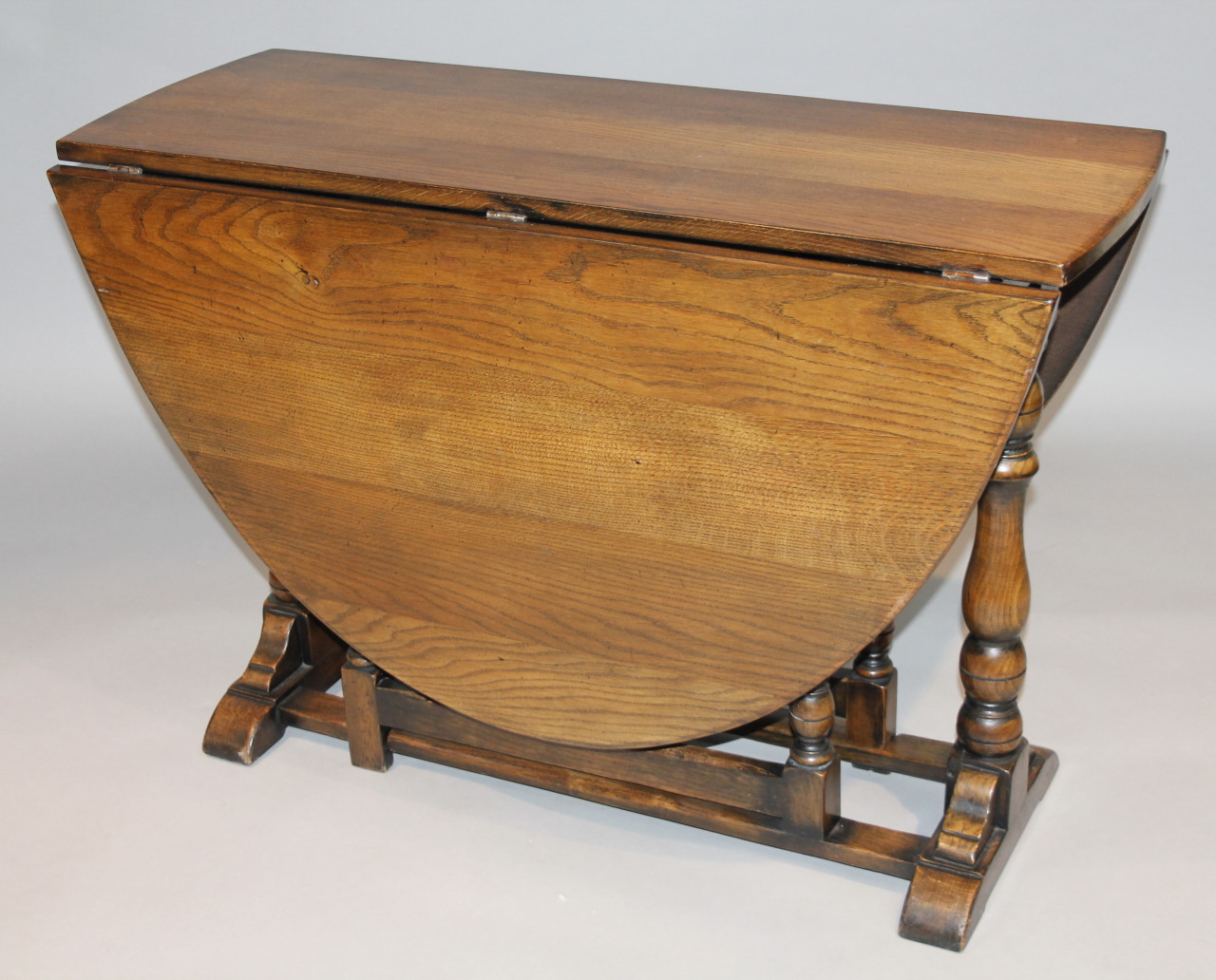 Appraisal: A Jacobean style oak dropleaf table the oval top raised