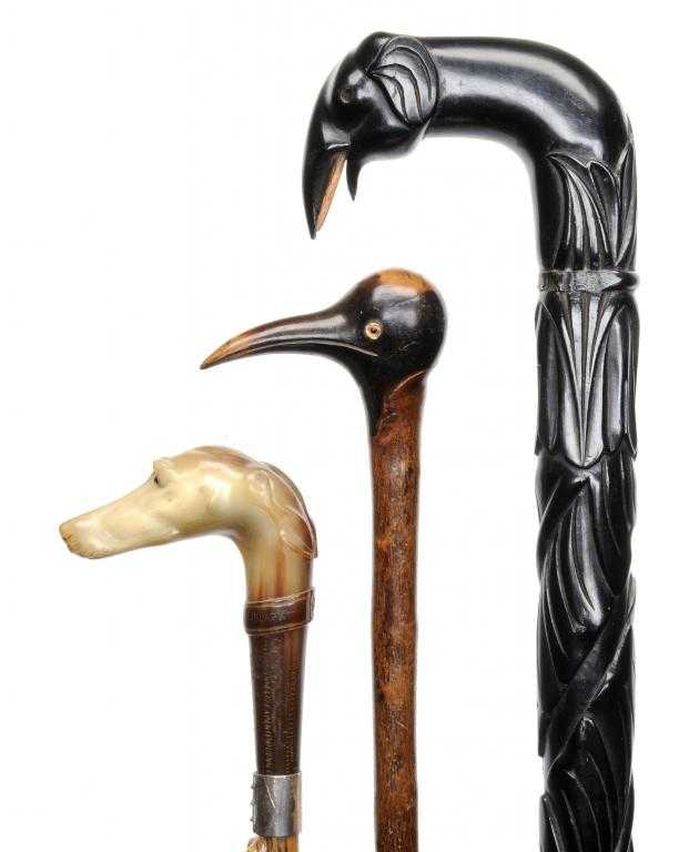 Appraisal: THREE ZOOMORPHIC WALKING CANES one of gnarled wood with carved