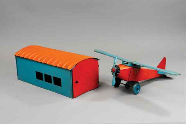 Appraisal: SCHEIBLE AIRPLANE WITH HANGAR Pressed steel done in colorful orange