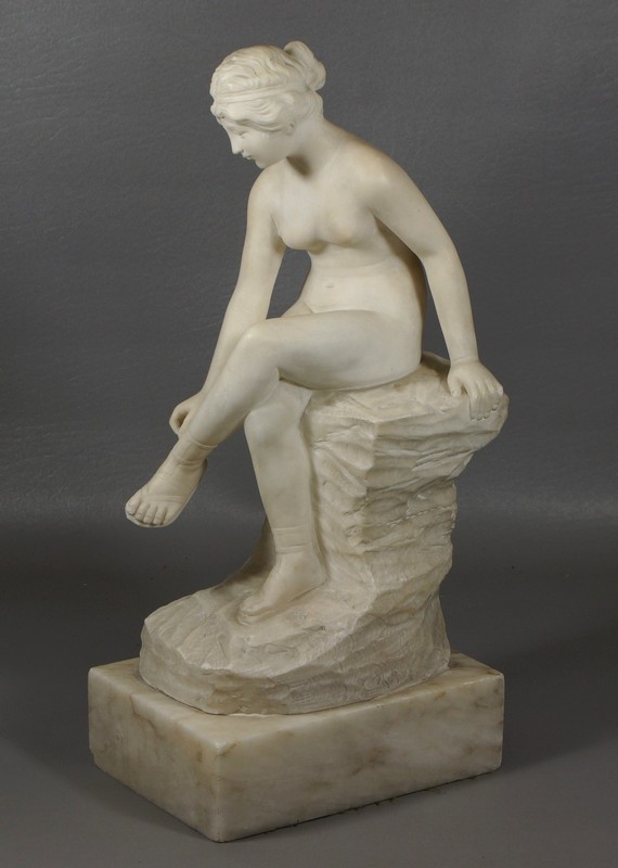 Appraisal: Carved alabaster figure of a seated nude woman adjusting her