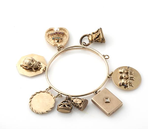 Appraisal: A gold charm bangle with gold and metal charms grs