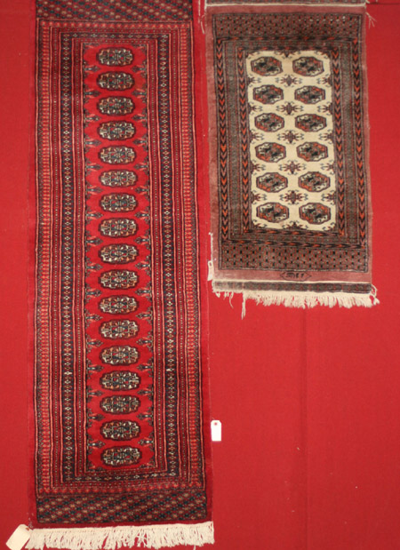 Appraisal: Two Pakistan Bokhara Ivory and Red Ground Rugs The first