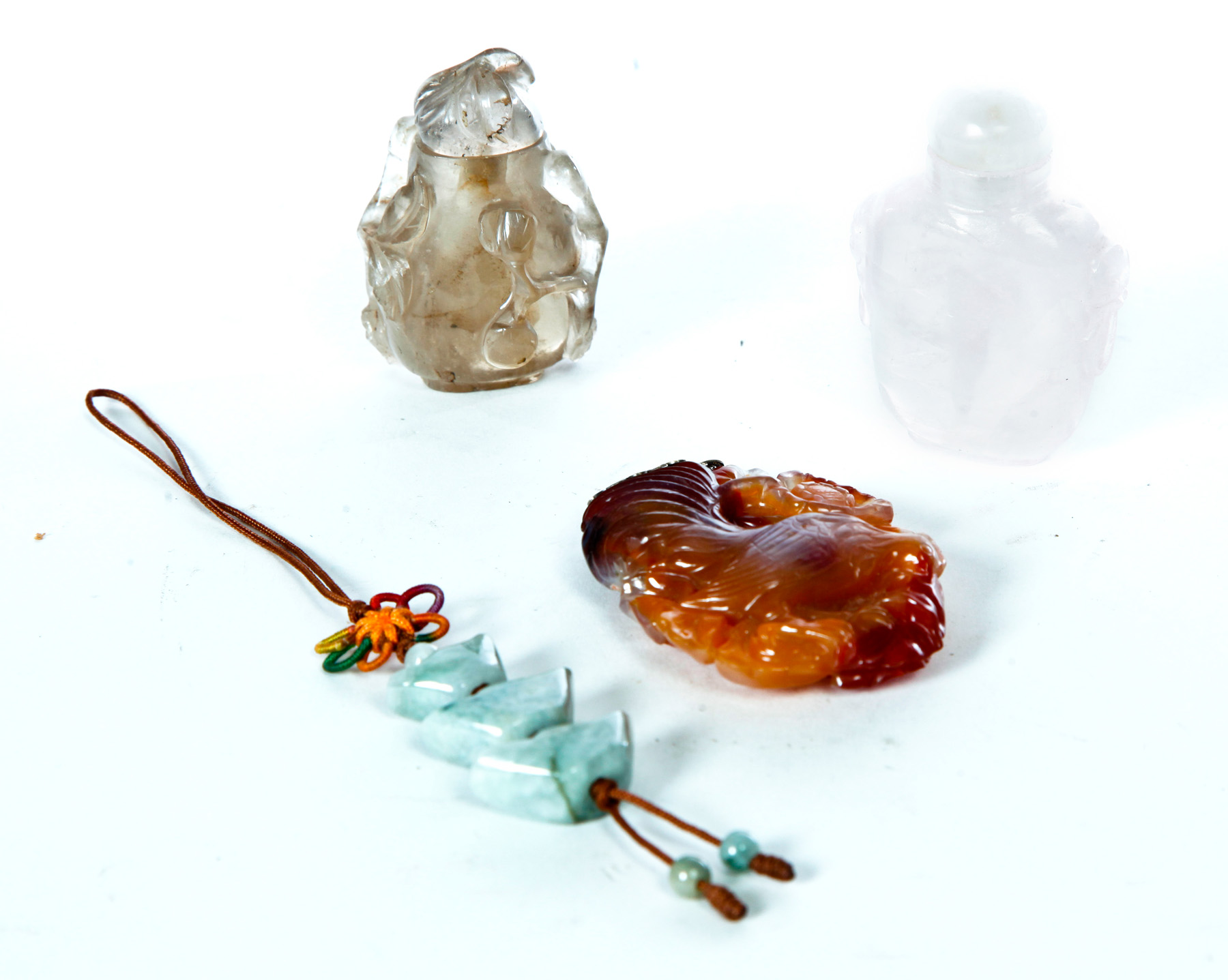 Appraisal: FOUR CHINESE SNUFF BOTTLES AND PENDANTS Twentieth century Jade drop