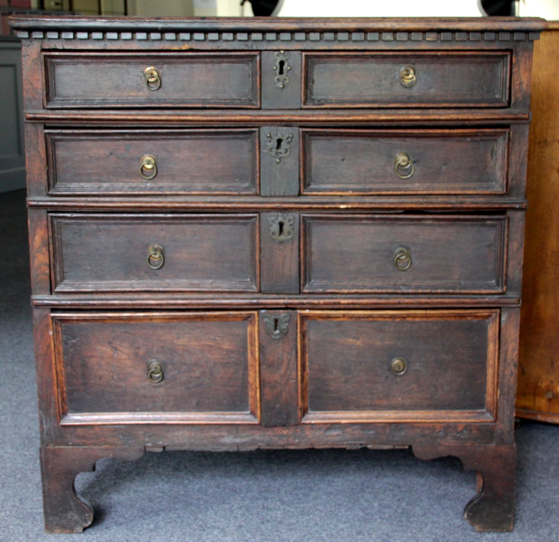 Appraisal: An oak chest of four long drawers with dentil moulding