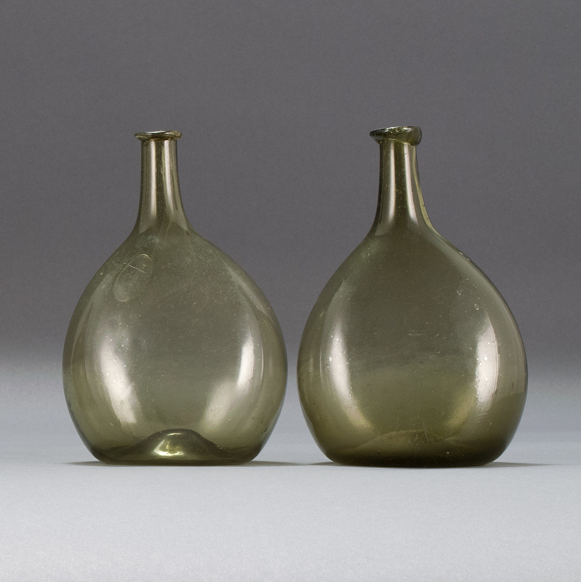 Appraisal: TWO FREE-BLOWN GLASS CHESTNUT FLASKS Early th CenturyIn olive green