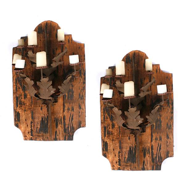 Appraisal: A pair of wrought iron wall sconces mounted on boards