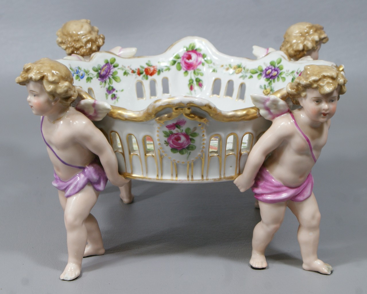 Appraisal: Schierholz porcelain pierced center basket with winged cherub supports inside