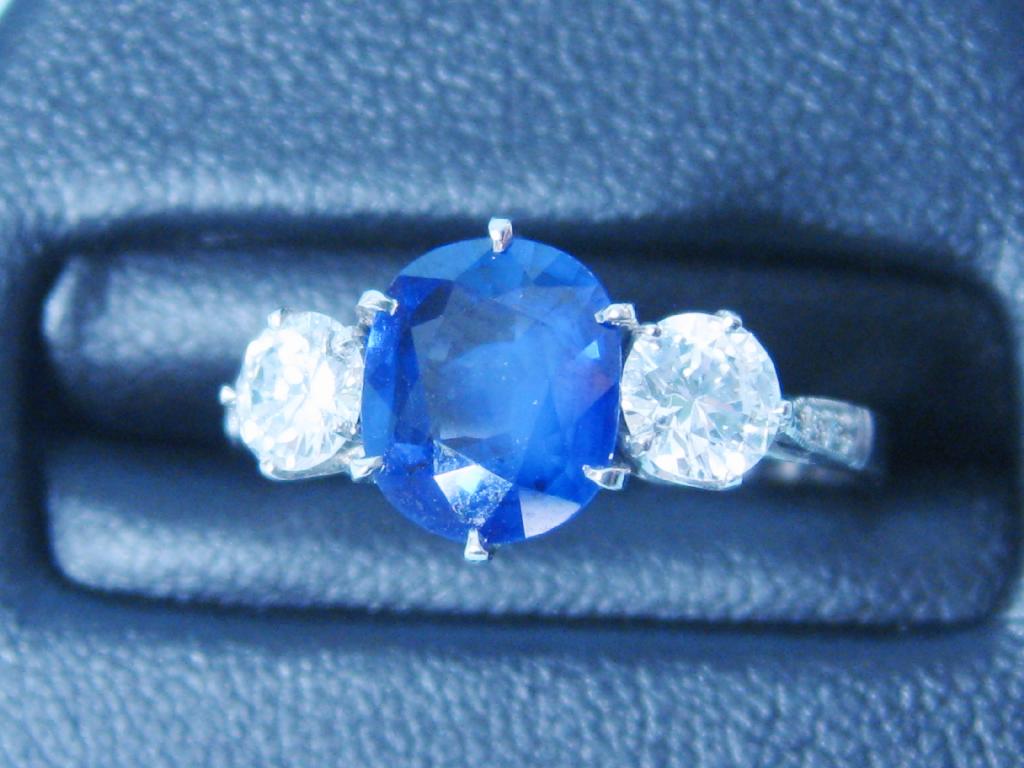 Appraisal: A three stone Sapphire and Diamond Ring the claw-set oval