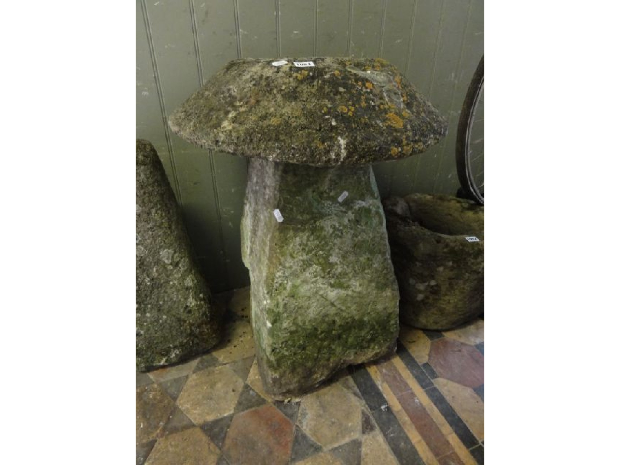 Appraisal: A weathered natural stone staddle stone and domed cap