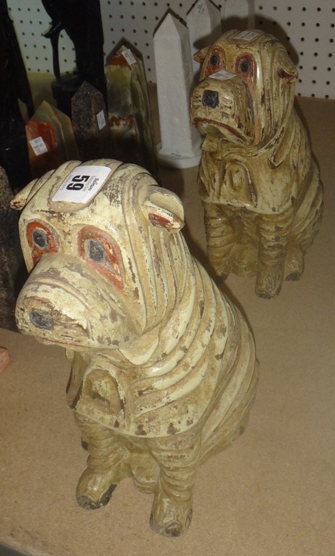 Appraisal: A pair of unusual carved figures of seated dogs and