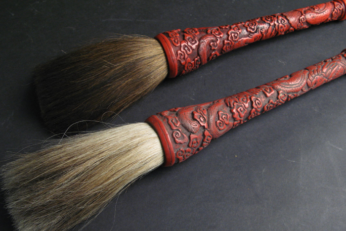 Appraisal: TWO CHINESE CINNABAR DUSTERS having floral and bird design Lengths