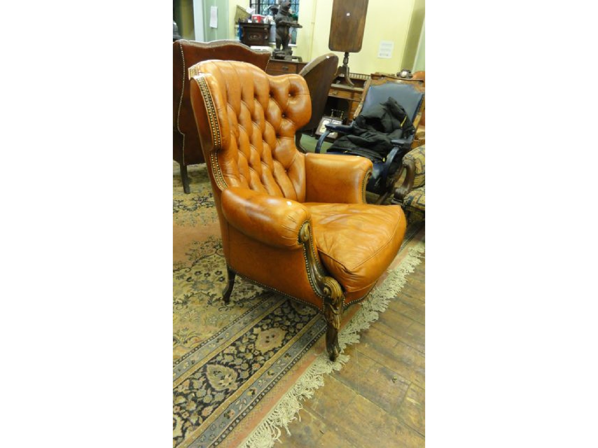 Appraisal: A flamboyant Georgian style upholstered armchair with scrolled arms and