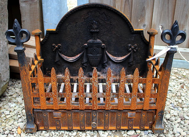 Appraisal: A SMALL CASE IRON FIRE GRATE with fleur de lis