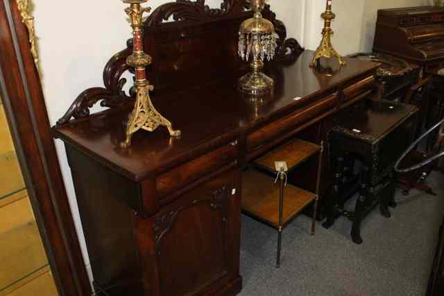 Appraisal: A TH CENTURY MAHOGANY PEDESTAL SIDEBOARD with raised and carved