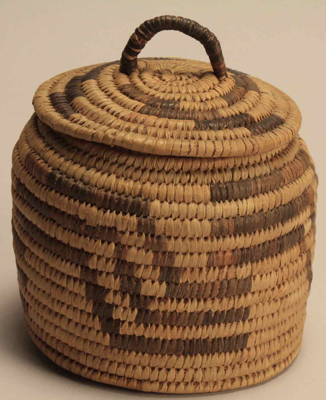 Appraisal: SOUTHWEST INDIANCOVERED BASKETCirca In cylinder form with geometric design Height