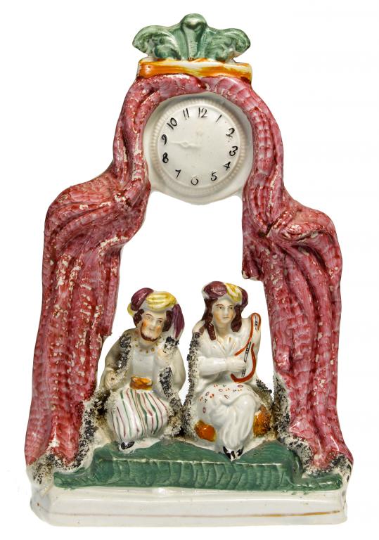 Appraisal: A STAFFORDSHIRE CLOCK GROUP OF TWO EASTERN MUSCIANS seated on