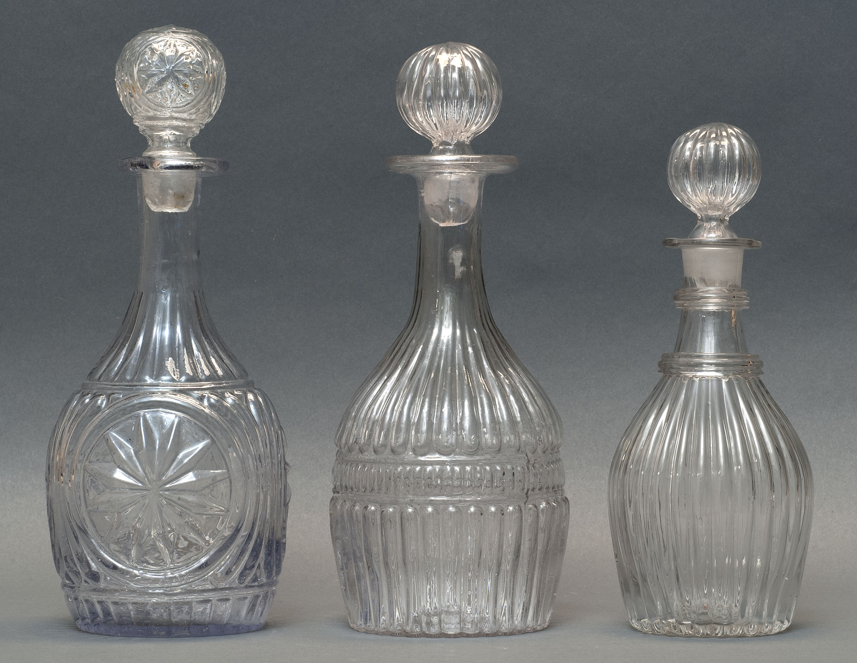 Appraisal: THREE CLEAR GLASS BLOWN -MOLD DECANTERS Second Quarter of the